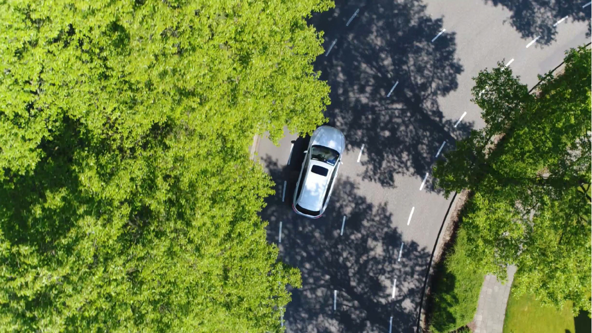 A certified used vehicle driving down a forest road.